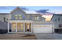 Beautiful two-story home with stone accents, covered porch, white garage door and a well-manicured lawn at 8864 Moonshimmer Trl, Littleton, CO 80125