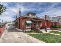 Charming brick home with a well-maintained lawn, driveway, and detached garage at 2421 W 38Th Ave, Denver, CO 80211