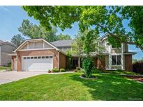 Charming two-story home featuring a well-manicured lawn and a classic brick and siding exterior at 4161 W Lake Cir, Littleton, CO 80123