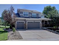 Beautiful two-story home boasts a three-car garage, gray siding, and meticulously maintained landscaping at 22921 E Euclid Cir, Aurora, CO 80016