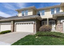 Charming townhome exterior with a stone-accented garage, front yard landscaping, and neutral color scheme at 3000 E 112 Ave # 102, Northglenn, CO 80233