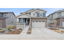 Charming two-story home featuring stone accents, gray siding, a two-car garage, and manicured landscaping at 8268 Mt Harvard Rd, Littleton, CO 80125