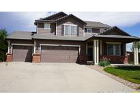 Charming two-story home with a three car garage and a well-manicured front lawn at 9616 Nucla St, Commerce City, CO 80022