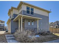 Inviting two-story home featuring a covered porch and a blend of gray and beige siding at 3744 Celestial Ave, Castle Rock, CO 80109