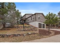 Two story home on a hill with stone accents, multiple windows, and a two-car garage at 8165 Tempest Ridge Way, Parker, CO 80134