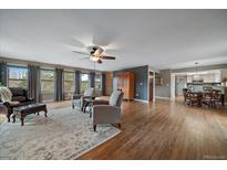Bright living room featuring hardwood floors, multiple windows, and comfortable seating arrangement at 8165 Tempest Ridge Way, Parker, CO 80134
