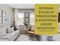 Bright living room featuring a modern couch, large windows, and neutral decor, offering a cozy and inviting space at 21823 E 8Th Ave, Aurora, CO 80018
