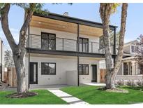 Two-story home features a white brick facade, black framed windows, wood ceiling, and a well-manicured lawn at 1374 Perry St, Denver, CO 80204