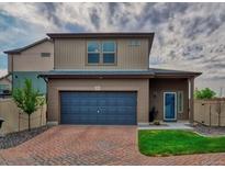 Charming two-story home featuring a brick driveway, a two-car garage, and a well-maintained lawn at 17910 E 54Th Ave, Denver, CO 80249
