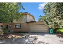 Charming home featuring a two-car garage and a well-maintained front yard with mature trees at 360 Upham St, Lakewood, CO 80226