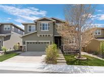 Charming two-story home with stone accents, a manicured lawn, and a two car garage at 5400 Heatherton Ln, Highlands Ranch, CO 80130