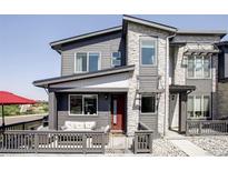 Stylish townhome featuring a blend of modern siding and stone accents, complemented by a cozy front patio at 2023 S Upham Way, Denver, CO 80227