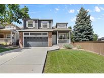 Charming two-story home with a well-maintained lawn, attached garage, and inviting front porch at 10295 Ravenswood Ln, Highlands Ranch, CO 80130