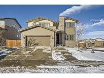 Two-story house with stone and siding accents, a three-car garage, and a landscaped yard at 14461 Mosaic Ave, Parker, CO 80134