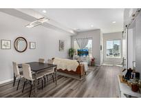 Bright living room featuring dining area, modern lighting, and stylish decor with hardwood floors at 5371 E 63Rd Pl, Commerce City, CO 80022
