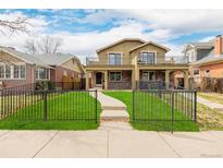 Inviting two-story home with a manicured front yard, wrought iron fence, and second story balconies at 1653 S Logan St, Denver, CO 80210