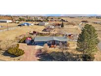 Charming home featuring mature landscaping, a cozy front porch and gravel driveway, with multiple outbuildings at 200 Bothun Rd, Berthoud, CO 80513