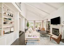 Bright, open living room with vaulted ceilings, built-in shelving, and a fireplace at 40 S Dexter St, Denver, CO 80246
