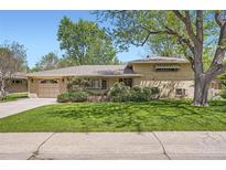Charming single Gathering home with a brick facade, well-maintained lawn, and mature trees casting shadows at 4490 Balsam St, Wheat Ridge, CO 80033