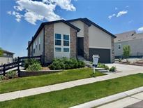 Charming two-story home boasts stone accents, a well-manicured lawn, and professional landscaping at 7202 Canyonpoint Rd, Castle Pines, CO 80108