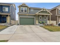 Two-story home with a gray exterior, green accents, and a spacious two-car attached garage at 18108 E 52Nd Ave, Denver, CO 80249