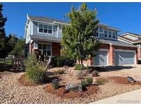 Charming two-story home with a well-maintained lawn, mature trees, and an attached two-car garage at 3902 Eagle Tail Ln, Castle Rock, CO 80104
