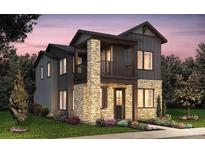 Modern two-story home boasts stone accents, dark siding, a small porch, and a well-manicured lawn at 8635 Hotchkiss St, Littleton, CO 80125