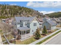 Charming two-story home with a covered front porch and a well-maintained yard with mature landscaping at 45 Bridge St, Breckenridge, CO 80424