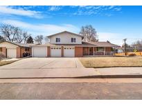 Charming two-story home featuring a brick facade, three-car garage, and a well-maintained front yard at 2907 S Fenton St, Denver, CO 80227