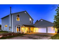 Charming two-story home featuring an attached garage and covered entryway, perfect for suburban living at 8370 Midsummer Ln, Elizabeth, CO 80107