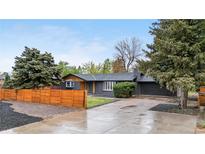 Charming single-story home with a spacious driveway, mature trees, and a privacy fence at 2320 S Valley Hwy, Denver, CO 80222