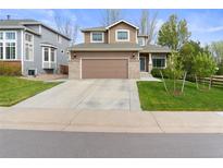 Charming two-story home features a large garage, brick accents, and well-maintained lawn at 17297 Opal Hill Dr, Parker, CO 80134
