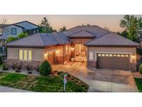 Charming single-story home featuring stone accents, a tile roof, and a well-manicured lawn at 2571 Hunters Pl, Highlands Ranch, CO 80129