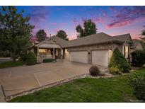 Charming single-Gathering home with a well-manicured front yard and an attached three-car garage at 1405 Castlepoint Circle, Castle Pines, CO 80108