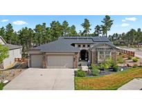 Beautiful single-story home showcasing a three-car garage and well-manicured lawn at 1734 Summerglow Ln, Monument, CO 80132