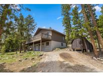 Charming two-story home featuring a spacious deck and a storage shed surrounded by lush trees at 24 Ski Pole Ct, Breckenridge, CO 80424