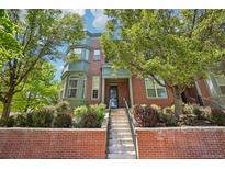 Charming brick townhome featuring lush landscaping and a welcoming entryway with a brick facade at 2933 Central Park Blvd, Denver, CO 80238
