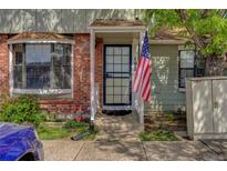 Inviting townhome entrance with brick accents and charming covered porch, accented with American flag at 8144 Washington St # 192, Denver, CO 80229