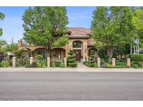Inviting two-story home with beautiful landscaping, mature trees, and a clay tile roof at 5335 E 2Nd Ave, Denver, CO 80220