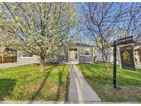 Charming gray home with a well-manicured lawn and blossoming tree at 940 Hooker St, Denver, CO 80204
