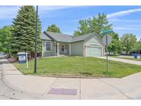 Charming single-story home with well-manicured lawn and an attached two-car garage at 9406 Troon Village Way, Lone Tree, CO 80124