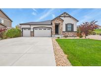 Beautiful home with stone accents, a well-manicured lawn, and a three-car garage at 21376 E Union Pl, Aurora, CO 80015