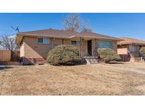 Charming single-story brick home with manicured landscaping, steps and covered entry at 3515 Grape St, Denver, CO 80207