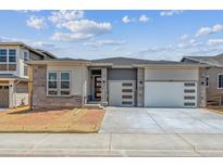 Charming single Gathering home with an attached two car garage and stone accents on the facade at 8672 Pennycress Dr, Littleton, CO 80125