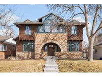Charming two-story home featuring a stone facade, arched entryway, and well-maintained lawn at 1270 S Jackson St, Denver, CO 80210
