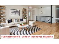Bright living room featuring stylish decor, light hardwood floors, and a decorative striped rug at 4582 N Fontana Way, Denver, CO 80239