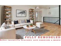 Bright living room with neutral colors, stylish furniture, and a striped accent rug at 4582 N Fontana Way, Denver, CO 80239