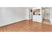 Spacious living room featuring wood-look flooring and an opening to the kitchen area at 8826 E Florida Ave # 117, Denver, CO 80247