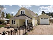Charming home with a front yard featuring a charming fence, inviting entrance, and attached garage in a serene setting at 345 Lower Glenway St, Palmer Lake, CO 80133