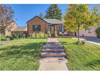 Charming brick home with a well-manicured lawn and inviting front porch at 1160 Holly St, Denver, CO 80220